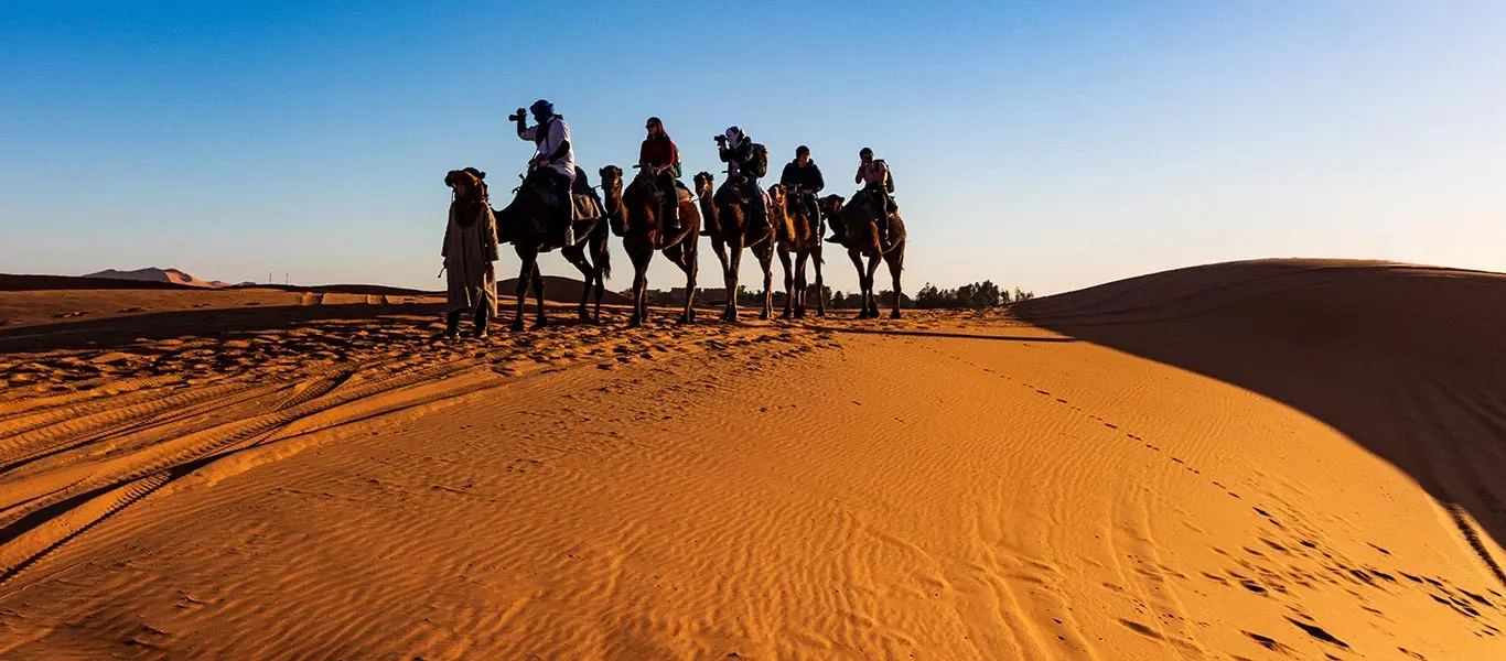 Group of people enjoying the camel safari in Indian dessert
